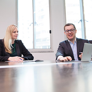 a photo of a hand using a computer and a woman writing for a UX agency in Sydney