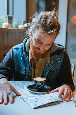 young man with man bun in a cafe with coffee