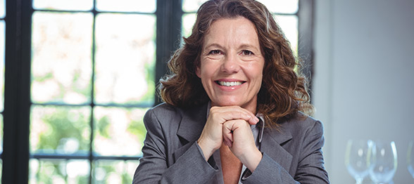 Mature business woman smiling with hands clasped