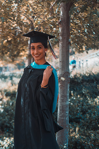 Young university graduate in her graduation gown	