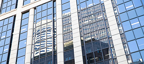 Office buildings in reflection of another building on a sunny day